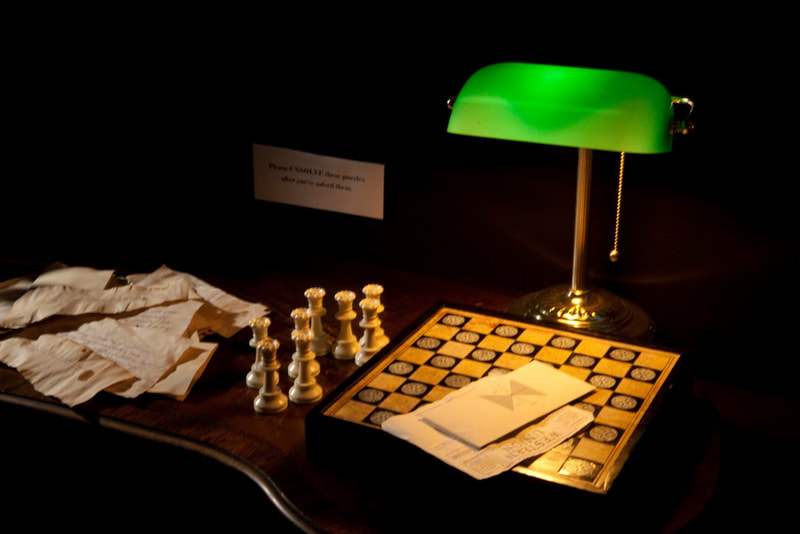 A chessboard, green lamp and pile of old-looking letters.